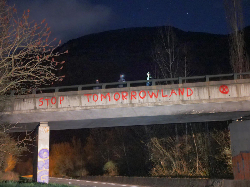 Inscription "Stop Tomorrowland" sur un pont, surl a route de l'Alpe d'Huez par des activistes d'Extinction Rebellion